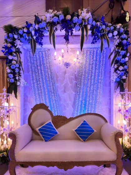 This couple's seating area was the centerpiece of a blue and silver themed Sangeet. The floral arch, shimmering curtains, and birdcage props filled with lights create a beautiful and unique backdrop.