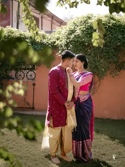 An intimate portrait of the couple in a garden, framed by leaves, creating a natural and private feel.