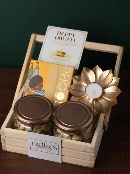 This budget-friendly wooden basket hamper feels luxurious. It contains two jars of coated nuts, Phool incense cones, and a golden flower diya, perfect for bulk corporate orders.