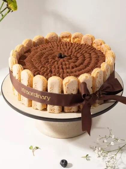 This is my take on a classic Tiramisu cake, with coffee-soaked ladyfingers, mascarpone cream, and a generous dusting of cocoa powder, all wrapped in our signature ribbon.