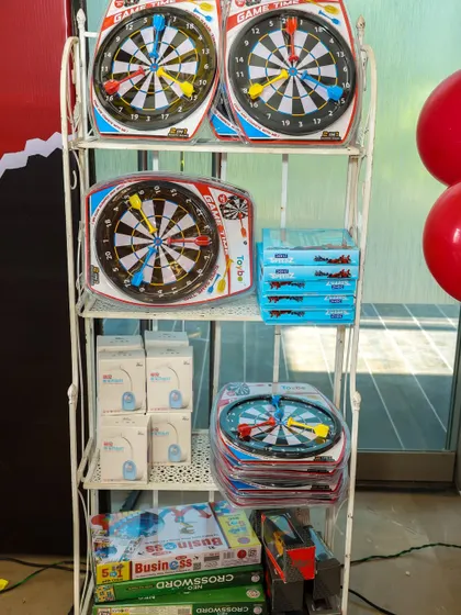 A selection of dart boards and board games ready to be given out as prizes or party favors at a superhero-themed event.