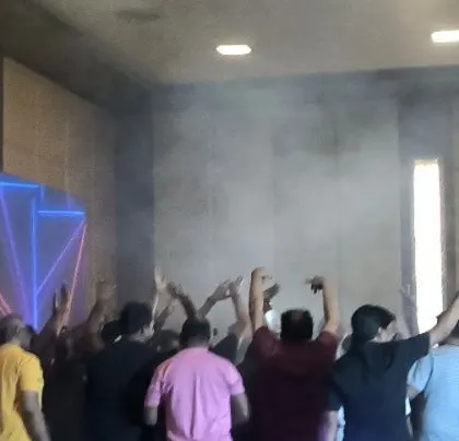The crowd is loving the music, with smoke adding to the atmosphere.