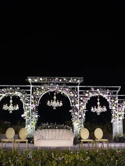 The mandap for Reeya and Parth's wedding, illuminated at night. The combination of floral arches, elegant chandeliers, and soft lighting created a magical and romantic atmosphere for their evening ceremony.