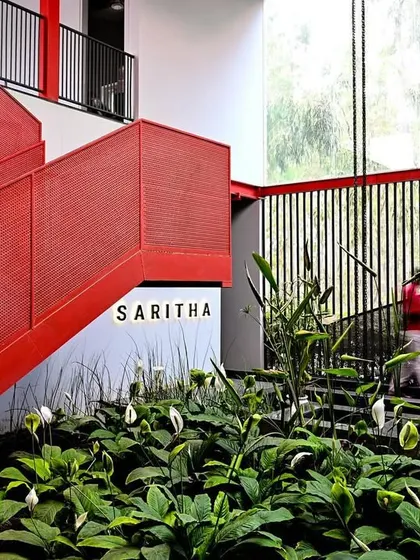 A motion-blurred figure ascends the red staircase, adding a sense of life and movement to the space. The design creates a dynamic experience for visitors, guiding them through the building.