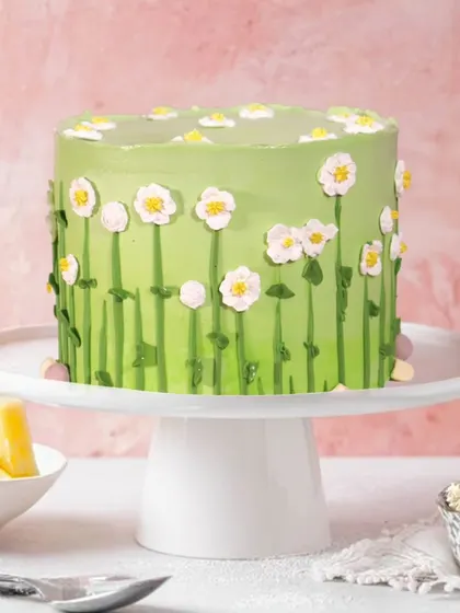 This blossoming pineapple cake was made for Pratibha’s special day in Noida. The simple yet charming design features a field of hand-piped daisies on a lovely green background.