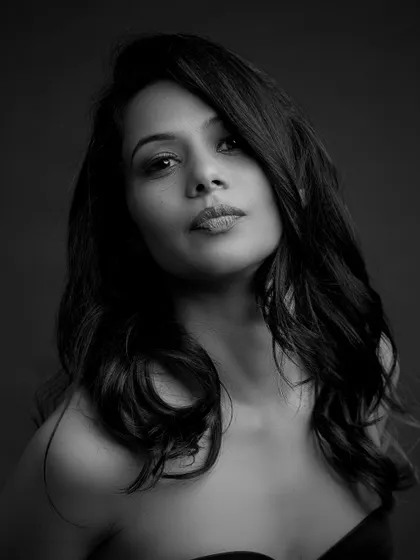 A close-up black and white portrait with a focus on emotion. The model's direct gaze is powerful and engaging.