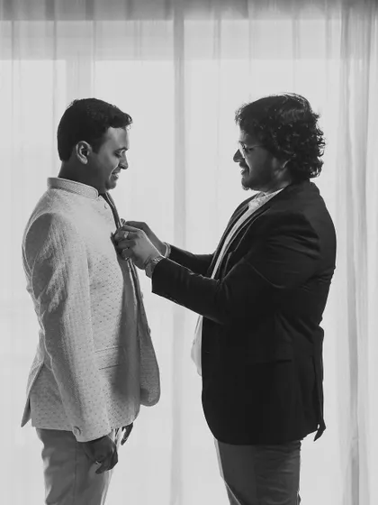 A candid black and white shot of me assisting the groom. It’s these personal interactions and my hands-on approach that ensure my clients feel supported and cared for.