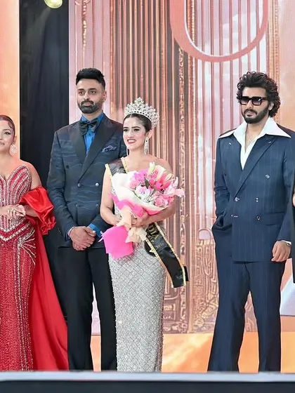 The winner's official photo on stage with celebrity judges. A shot like this is a huge asset for a model's career and portfolio.