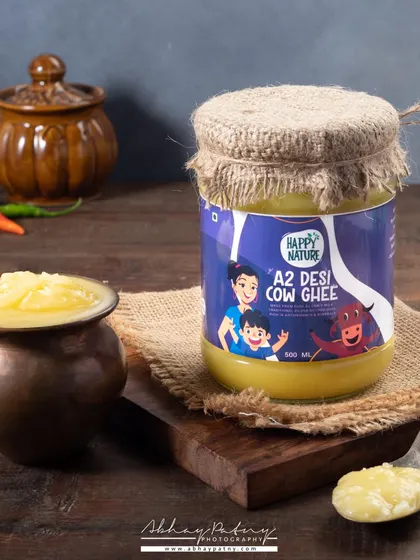 For this A2 Desi Cow Ghee, I used rustic props like the small brass pot and wooden board to create a traditional, farm-fresh feel that aligns with the product's natural branding.