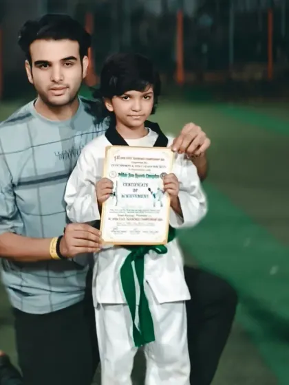 This student has earned his green belt, a sign of his growing skill and commitment to Taekwondo.