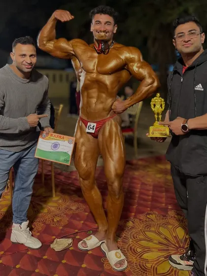 One more gold medal in bodybuilding for Team Ashish. Posing with the trophy, the certificate, and the physique that earned the win.