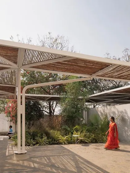 Pockets of green flourish under the cut-outs in the bamboo canopy. These small courtyards bring nature into the heart of the school and provide shaded spots for students to gather.