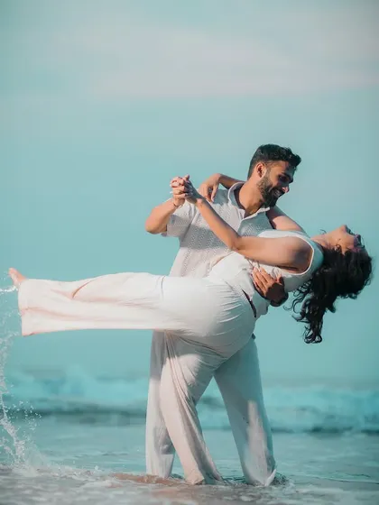 A dynamic and romantic shot of the couple dancing in the waves on a Goa beach. The splash of water adds energy and a touch of magic to the photo.
