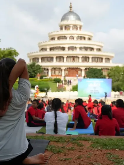 A participant holds Gomukhasana (Cow Face Pose) arms, a posture that opens the shoulders and chest. Our sessions guide you through various asanas to release physical tension stored in the body.