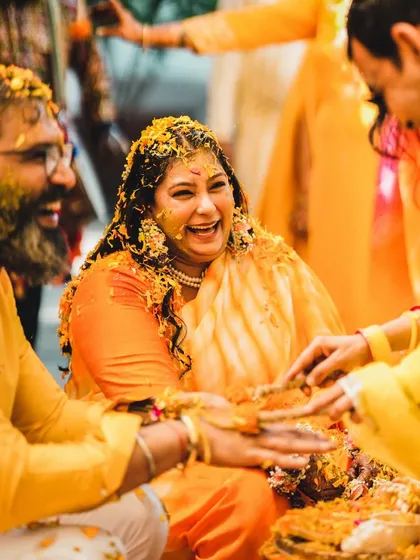 Laughter and love fill the air at this Haldi ceremony. This candid shot captures a genuine moment of happiness and family bonding during the pre-wedding rituals.