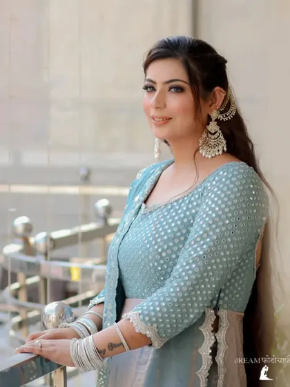 A close-up portrait of Mannat, her smile and traditional earrings shining in the natural light.