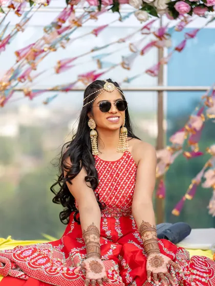 Mehendi magic with a cool pair of sunglasses. This bride is all about having fun, and her makeup is bright and shimmery to match her vibe.