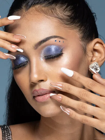 A beauty shot focusing on the model's nails and eye makeup, a great shot for a nail artist or brand.