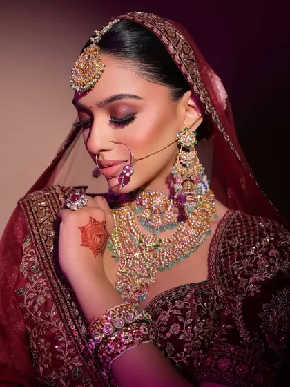 This shot captures the rich textures of the velvet lehenga and the intricate jewellery, with the makeup providing a perfect, radiant balance.