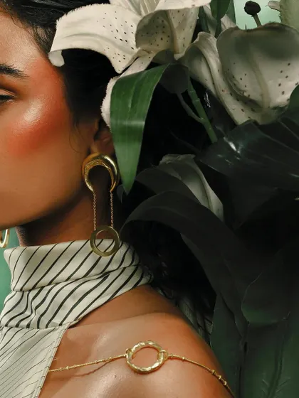 A detailed close-up on the jewelry from the Batoki.art campaign, showing the texture of the gold earrings and body chain. This shot is perfect for showcasing product craftsmanship.