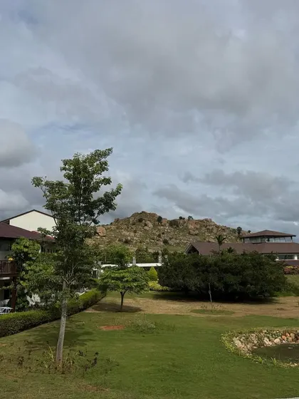 The retreat buildings sit comfortably within the landscape under a cloudy sky. This image shows that our sanctuary is beautiful and welcoming in all weather, offering a constant sense of peace.