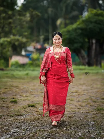 A full-length shot of our bride Iva, walking with grace in her custom red saree. Every detail was designed to make her feel special.