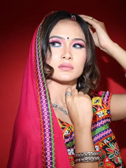 A special look for Navratri. This makeup features dramatic, colorful eyes and is paired with a traditional embroidered choli and silver jewelry.