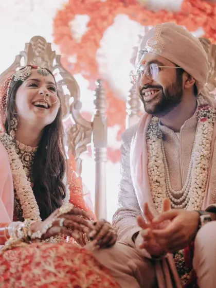A candid moment of laughter between the bride and groom at the mandap. This shot perfectly captures the joy and ease that a well-planned wedding allows a couple to feel.