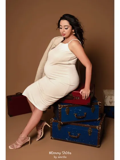 Another pose from the travel-themed maternity shoot. The windswept hair and natural makeup create a sense of effortless style.