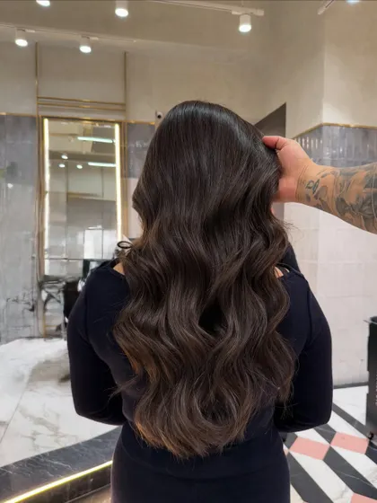 My hand running through the ash brown hair, showcasing its health, shine, and beautiful, cool-toned dimension.