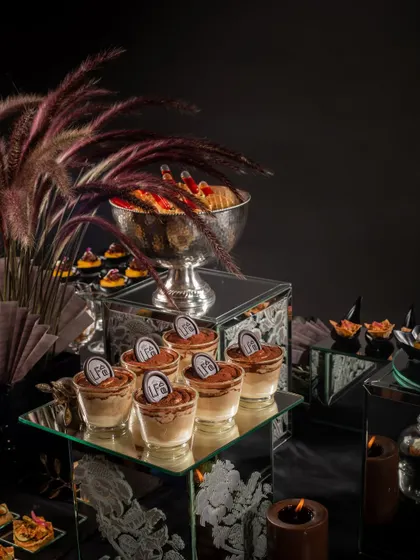 Our signature Tiramisu cups with an LFC chocolate seal, part of a dark and moody Diwali party setup. This dessert is a sophisticated and delicious end to a festive meal.