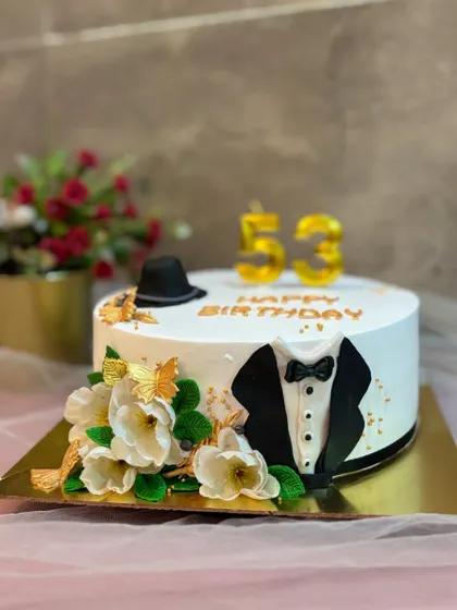 A classic cake for a true gentleman. This design features a fondant tuxedo, a top hat, and the number 53 to mark a special birthday.