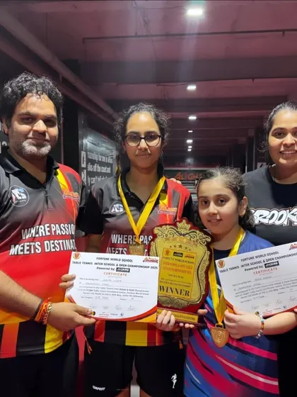 The winners of a girls' team event at the Fortune World School tournament, proudly holding their shield.