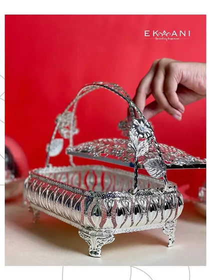 A touch of grandeur for your festive spread. This rectangular silver serving basket, with its ornate floral handle and intricate cutwork, is more than just serveware, it is a statement.