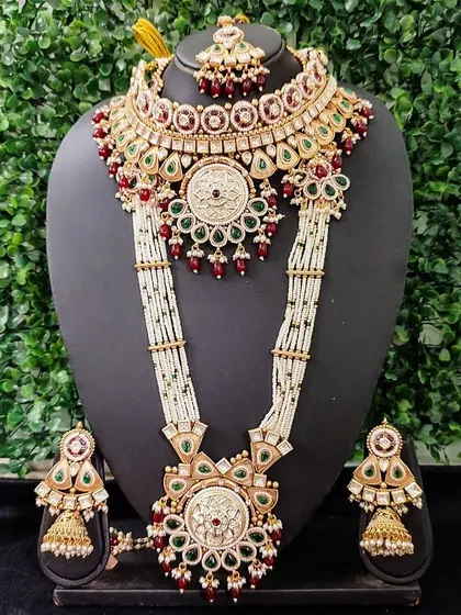 This stunning bridal set with a unique floral and geometric design is available for purchase. The combination of a choker and long necklace makes it a versatile addition to any bridal trousseau.