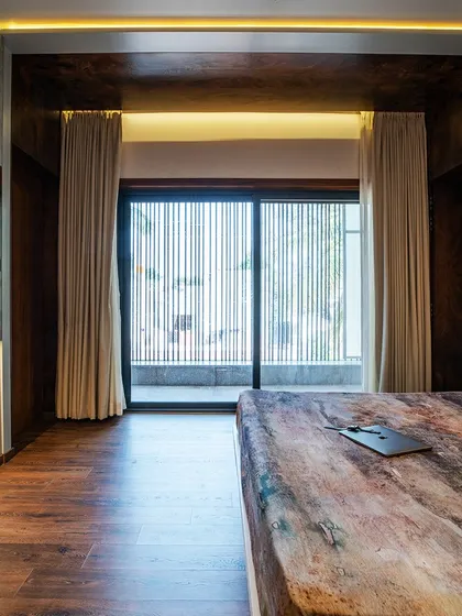 For the 'VerticalNest' project, the bedroom seamlessly merges with an open balcony. This design creates an expansive feel, connecting the private interior space with the outdoors and flooding the room with natural light.
