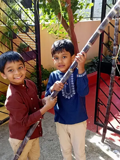 Two more boys happily posing with the sugarcane.