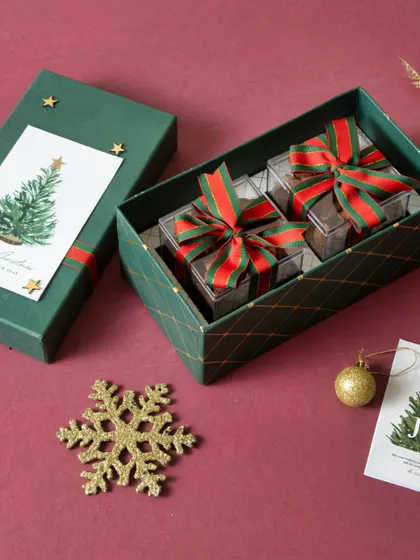 A beautifully wrapped Christmas gift box containing two smaller boxes of our treats, tied with festive ribbons.
