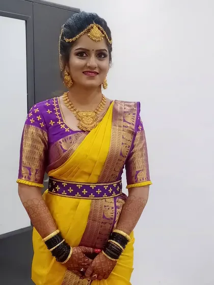 This image captures the bride's final look. The combination of the vibrant saree, intricate gold jewelry, and flawless makeup creates a truly memorable and traditional bridal style.