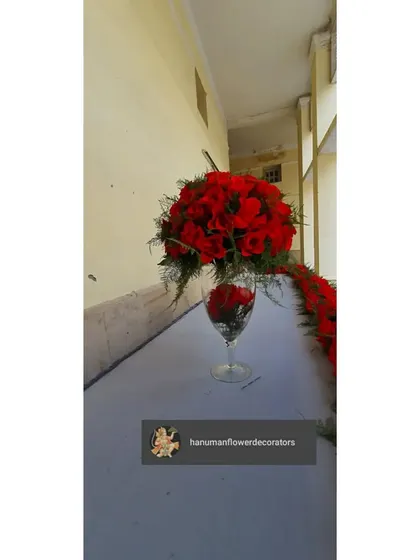A close-up of one of the table centerpieces from the convocation event. The arrangement of red roses in a wine glass is a simple yet elegant detail that elevates the overall decor.