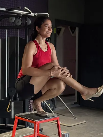 Who says you can't be strong and stylish? This photo captures the fun side of fitness, showing that the strength and balance you build in the gym, like with this pistol squat on a box, carries over into every part of your life.