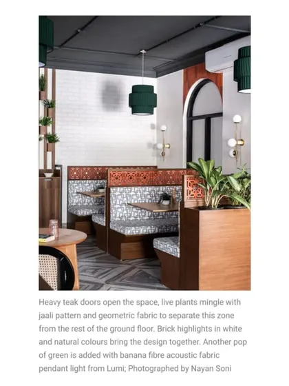 For more private seating, I designed these booths separated by teak partitions with a traditional jaali pattern. The geometric fabric and green pendant lights add a pop of color and modern flair.
