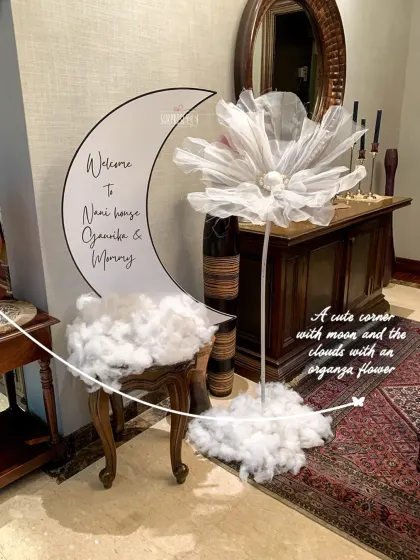 A cute corner with a personalized moon sign that reads "Welcome to Nani house." The fluffy clouds and a delicate organza flower added to the whimsical and gentle atmosphere.