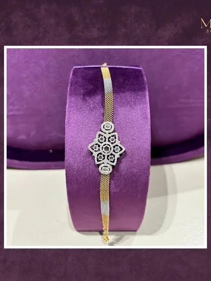 This exquisite bracelet features a central floral diamond motif on a two-toned gold band. It's a piece where every detail is designed to shine and turn heads.