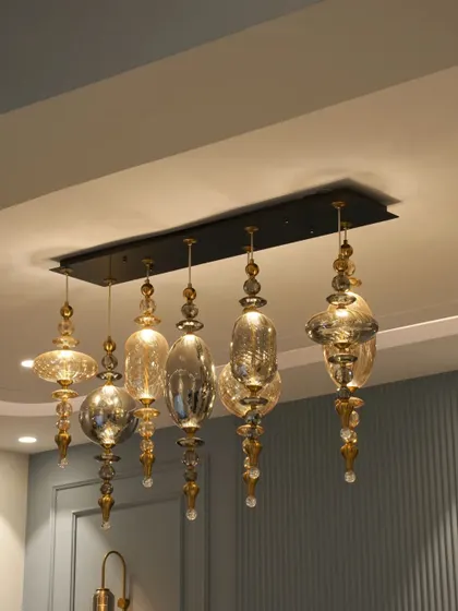 A close-up of the ornate glass chandelier that serves as a stunning centerpiece in the Noida dining room, adding a touch of traditional luxury.