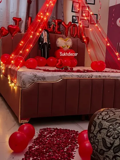 A detailed shot of the bed and floor decor, highlighting the rose petal path and the heart-shaped balloon arrangements we use to complete the romantic theme.