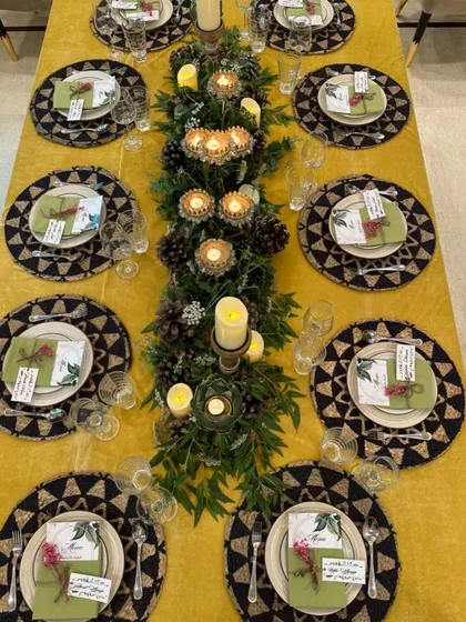 Beyond buffets, we craft exquisite sit-down dining experiences. This intimate dinner setup features a beautifully decorated table with lush greenery, candles, and personalized place settings, promising an evening of curated elegance.