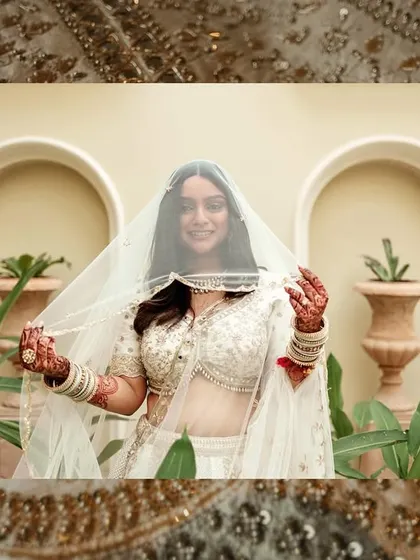 A beautiful portrait of the bride, Sanika, framed by her white veil and the elegant architecture of the Hilton, Mumbai.