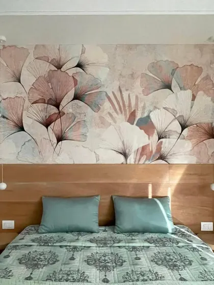 This bedroom gets a soft and artistic touch with a custom wallpaper featuring delicate ginkgo leaves. The design behind the headboard serves as a beautiful, calming focal point.