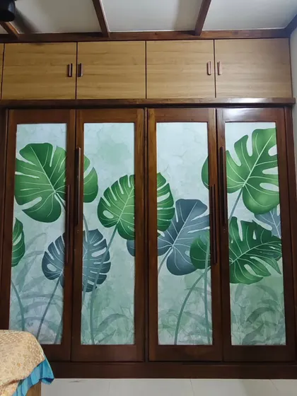 Wallpaper can also be applied to furniture. Here, I've installed a monstera leaf pattern wallpaper on the glass panels of a wooden wardrobe for a custom look.